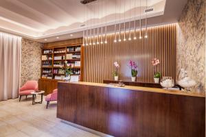 a hotel lobby with a reception desk and pink chairs at Hotel La Palomba in Mondavio