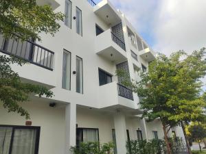 a white building with black windows and trees at H&M Boutique in Kampot