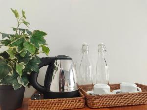 a black kettle and two glass bottles on a table at H&M Boutique in Kampot