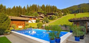a swimming pool in the middle of a yard with houses at Chalet Nina in Reith im Alpbachtal