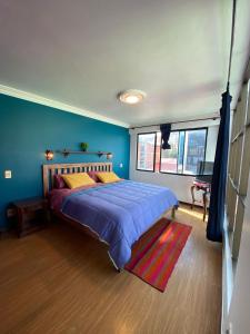 a bedroom with a large bed with blue walls at The Rooftop Bolivia in La Paz