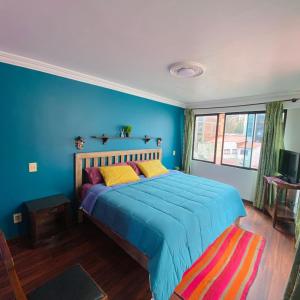 1 dormitorio con 1 cama con pared azul en The Rooftop Bolivia, en La Paz