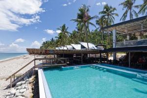 a resort with a swimming pool next to the beach at Surigao Dream Beach Resort in Tigbao
