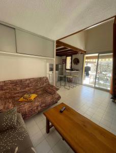 sala de estar con sofá y mesa en Charmante Villa de vacances en Cap d'Agde