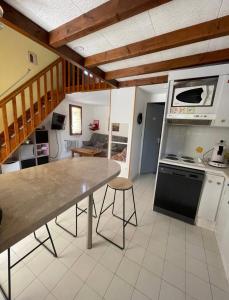 cocina con mesa y fogones horno superior en Charmante Villa de vacances en Cap d'Agde