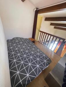 een slaapkamer met een zwart-wit bed in een kamer bij Charmante Villa de vacances in Cap d'Agde