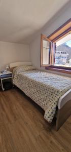 1 dormitorio con cama y ventana en Appartamento in una valle di Luce en Pizzoferrato
