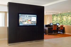 una oficina con una pared con un televisor. en Courtyard by Marriott Huntsville University Drive, en Huntsville