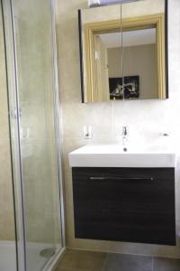 a bathroom with a sink and a shower at Kings Cross Inn Hotel in London