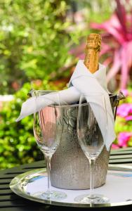 a bottle of champagne in a bucket on a table with two glasses at L'Auberge Carmel, Relais & Chateaux in Carmel