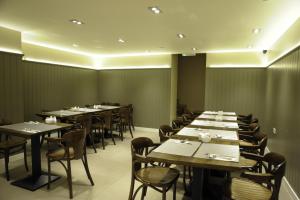 a dining room with long tables and chairs at Kings Cross Inn Hotel in London