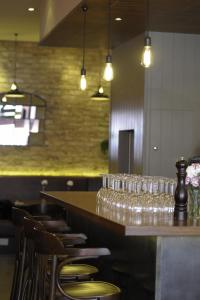 a bar with glasses on a counter in a restaurant at Kings Cross Inn Hotel in London