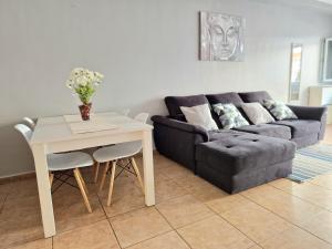 a living room with a couch and a table at Spacious Chalet Next to the Sea - Airport in San Isidro
