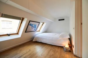 a white bedroom with a bed and a window at The Union Penthouse in Oxford