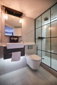 a bathroom with a toilet and a sink and a shower at The Union Penthouse in Oxford