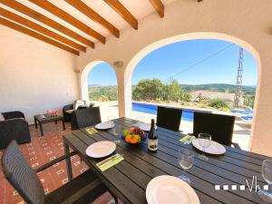 a dining table with a view of a pool at VH CostaBlanca - OSALVA in Benissa