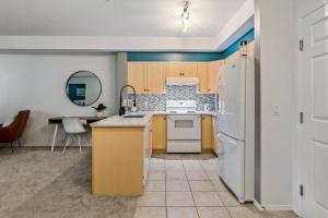 a kitchen with a white refrigerator and a table at Gorgeous Condo, Perfect Okanagan Getaway 1207 in Kelowna