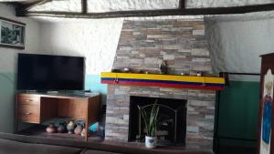 a living room with a fireplace with a tv at Apartaestudio tipo cabaña in Bogotá