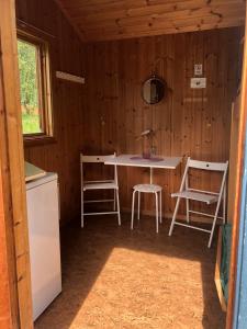 a kitchen with a table and chairs in a cabin at Delsbo Camping in Delsbo