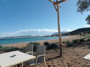 una mesa y sillas en una playa de arena en Sea captains deck, en Kato Daratso
