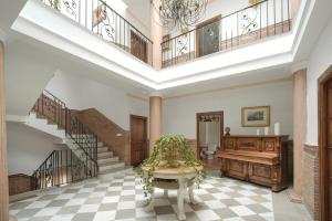 a living room with stairs and a table and a piano at Villa La Gaviota - Piscina, jardín y barbacoa junto Ruta del Gollizno in Moclín