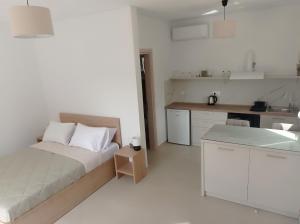1 dormitorio blanco con 1 cama y cocina en Sea captains deck, en Kato Daratso
