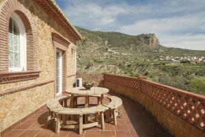 a patio with a table and chairs on a balcony at Villa La Gaviota - Piscina, jardín y barbacoa junto Ruta del Gollizno in Moclín