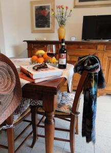 a table with a bottle of wine and a glass at Appartamento con giardino a 5 minuti dal mare in Torre del Lago Puccini