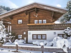 uma cabana de madeira na neve com árvores cobertas de neve em Chalet Nina em Reith im Alpbachtal