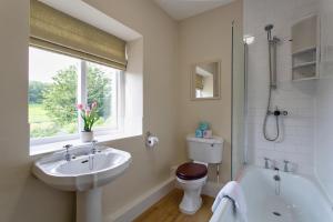 łazienka z umywalką, toaletą i wanną w obiekcie 9 Gargrave Road at Broughton Sanctuary w mieście Broughton