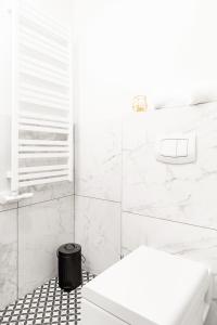 a white bathroom with a white tub and a toilet at HOUSEHOST Apartment: Św.Gertrudy 10/0.2 in Krakow