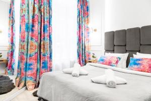 two beds in a bedroom with colorful curtains at HOUSEHOST Apartment: Św.Gertrudy 10/0.2 in Krakow