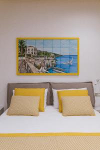 una camera da letto con un dipinto sopra un letto con cuscini gialli di Casa La Bifora a Sorrento
