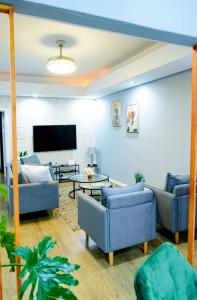 Mdumela Stays 2 Bedroom Modern City Apartment في بيترماريتزبورغ: غرفة معيشة مع كنبتين وتلفزيون