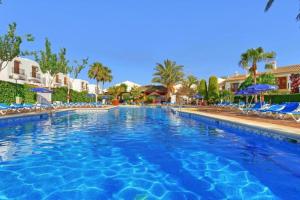 a swimming pool at a resort with chairs and umbrellas at Marisol Apartment Vera Playa Andalusia 150 m from the Beach, Spain in Vera