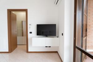 a living room with a tv on a white wall at Parcheggio Privato - Appartamento a Milano in Corsico