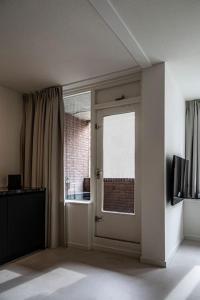 een lege kamer met een deur en een raam bij Cloud Nine - romantic & design app in city center! in Dordrecht