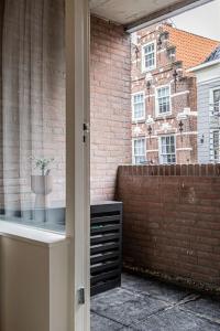 een raam met uitzicht op een bakstenen gebouw met een potplant bij Cloud Nine - romantic & design app in city center! in Dordrecht