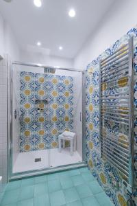 bagno con doccia e piastrelle bianche e blu di Casa La Bifora a Sorrento