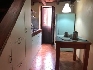 cocina con mesa y nevera en Grazioso appartamento in centro storico, en Terracina