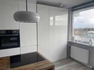 cocina con paredes blancas, mesa y ventana en Nadmorski Apartament, en Gdansk