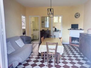 a kitchen and dining room with a table and a couch at Maison Jullouville, 3 pièces, 4 personnes - FR-1-361-69 in Jullouville-les-Pins