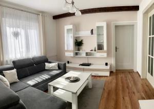 sala de estar con sofá y mesa en FeWo Obstfelderschmiede, en Mellenbach-Glasbach