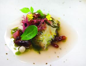 a white plate with a piece of food with vegetables at L'Auberge Carmel, Relais & Chateaux in Carmel