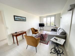 ein Wohnzimmer mit einem Sofa, Stühlen und einem Tisch in der Unterkunft Appartement Donville-les-Bains, 3 pièces, 4 personnes - FR-1-361-433 in Donville-les-Bains