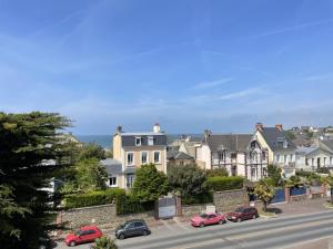 a city street with cars parked in front of houses at Appartement spacieux près de la plage et commerces, 4 couchages - FR-1-361-433 in Donville-les-Bains