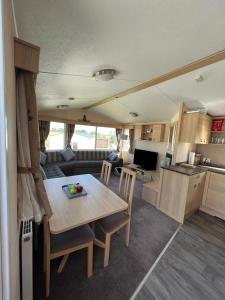 una cocina y comedor con una mesa en una caravana en Lotus Lodge Northumberland, en Felton