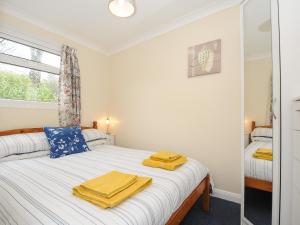 ein Schlafzimmer mit einem Bett mit gelben Handtüchern darauf in der Unterkunft 21 The Glade in Bude