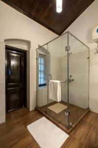 a bathroom with a shower with a glass door at amã Stays & Trails - Wayside Villa, Kurseong in Karsiyang