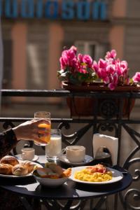 a table with plates of food and a person holding a glass at The Grey in Naples